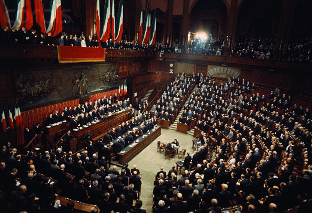 29 Dec 1971, Rome, Italy --- Senators and Deputies fill the flag-draped Chamber of Deputies to witness President Giovanni Leone (standing at second highest row of desks facing deputies) take the oath of office. --- Image by © Bettmann/CORBIS